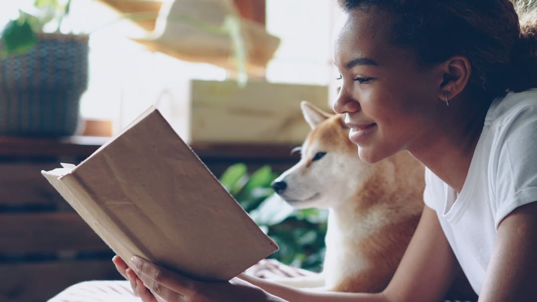 support animal registration. A woman reads a book with her dog.