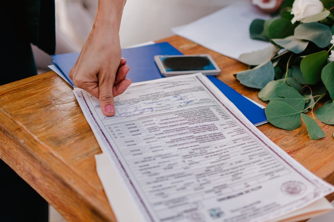 support animal laws. Person pointing at a marriage certificate on a wooden table.