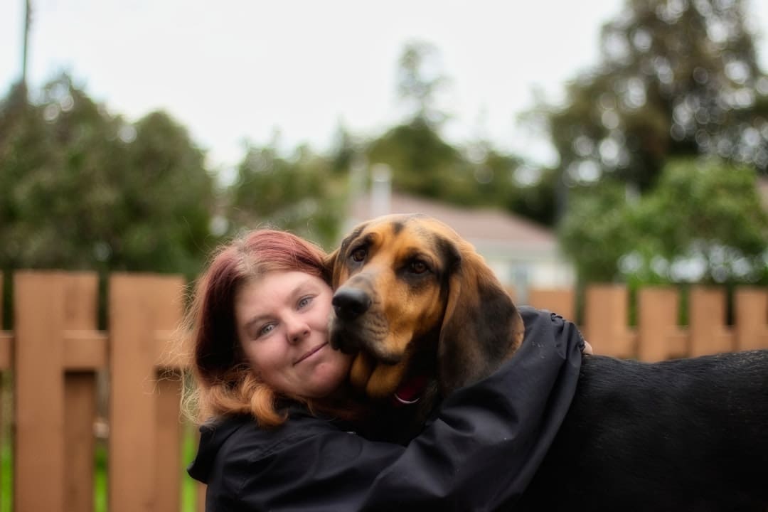 support animal panic — a woman hugging a dog in a fenced in area