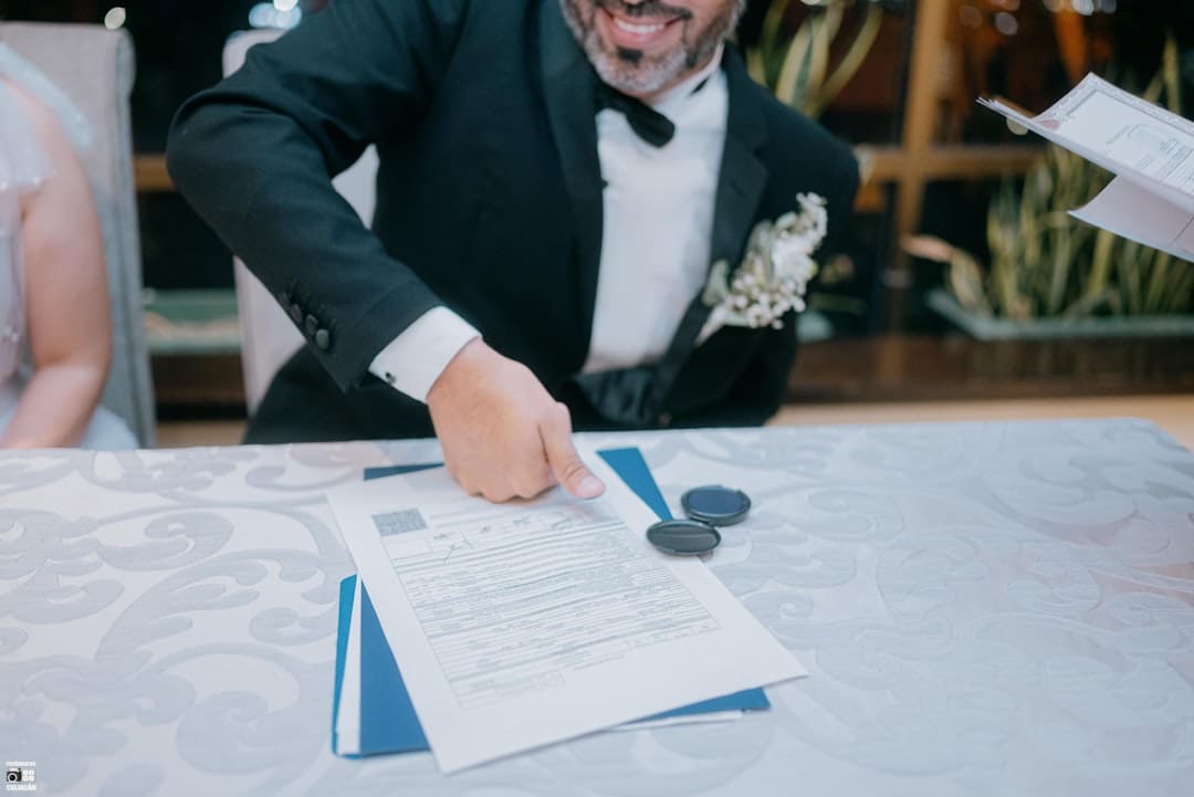 Texas support animal law — Groom in tuxedo signing wedding documents with a smile.