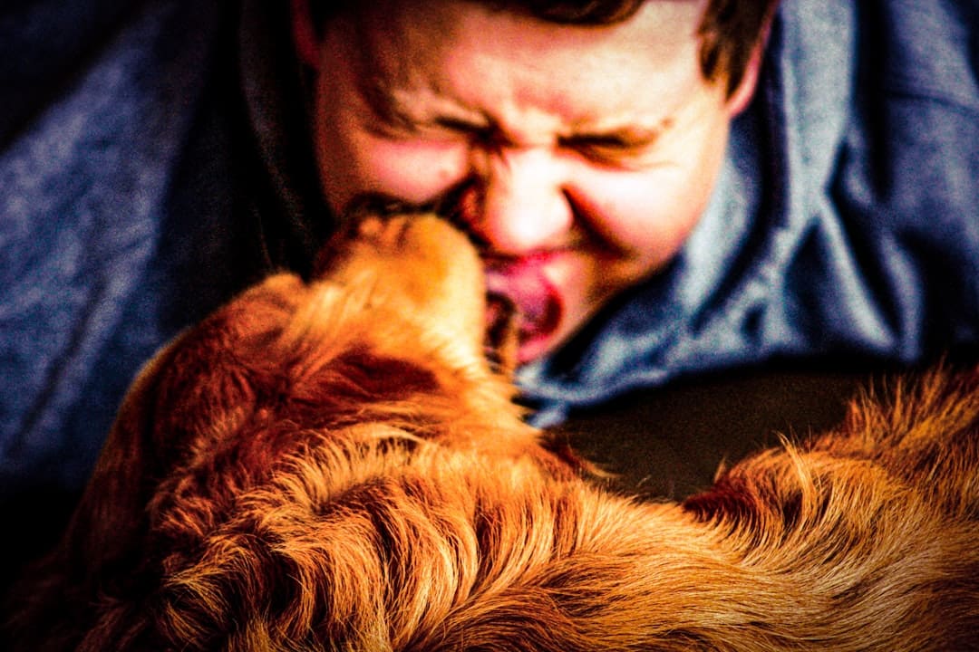 depression support animal — a man laying on a bed kissing a dog