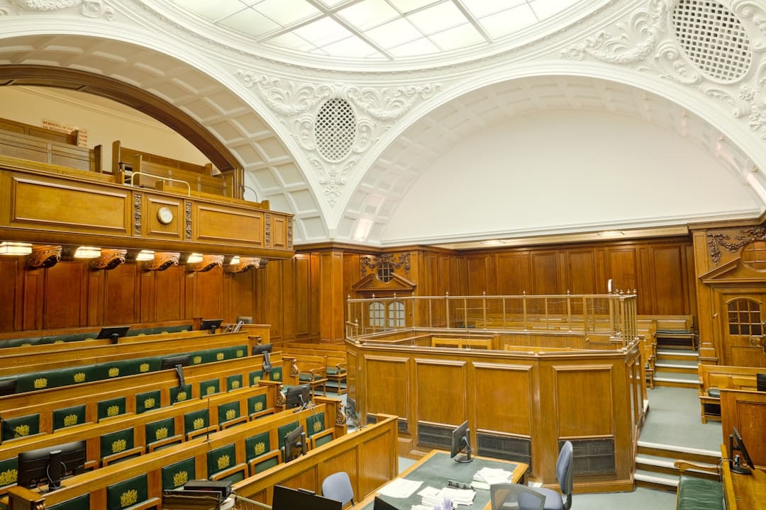nonprofit mental health — Empty ornate courtroom interior with wooden paneling and green seats.
