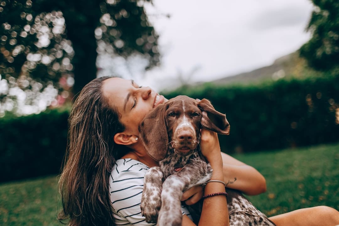 panic disorder support animal — woman in white and black stripe tank top hugging brown and white short coated dog