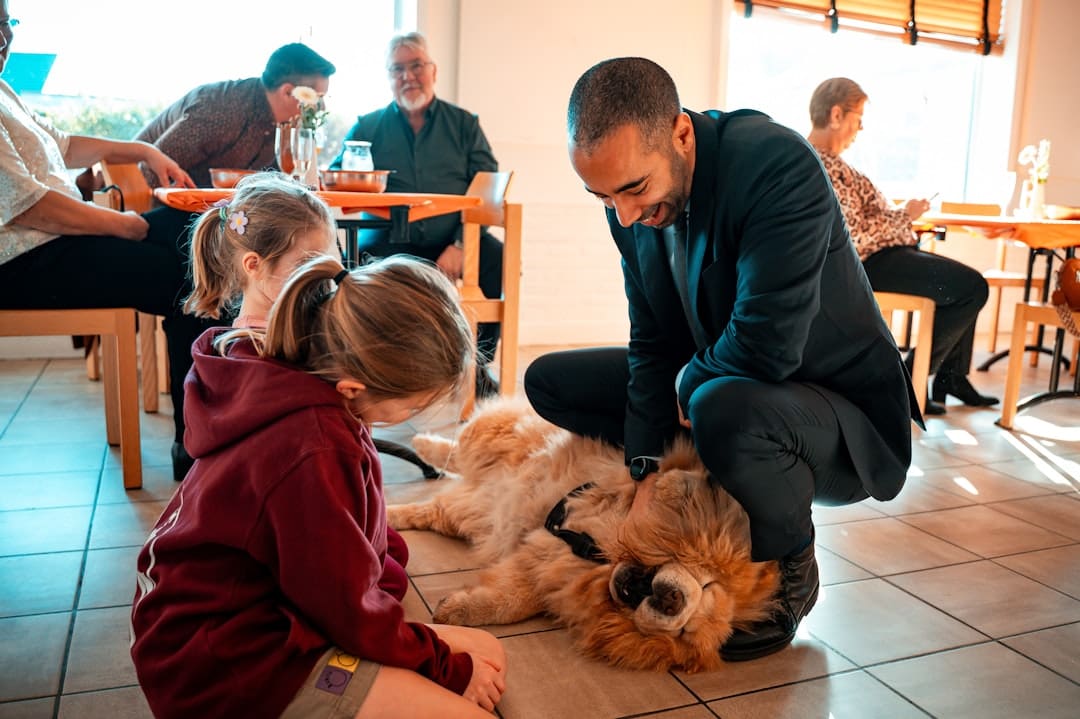 support animal vest — Man pets a fluffy dog with a child watching