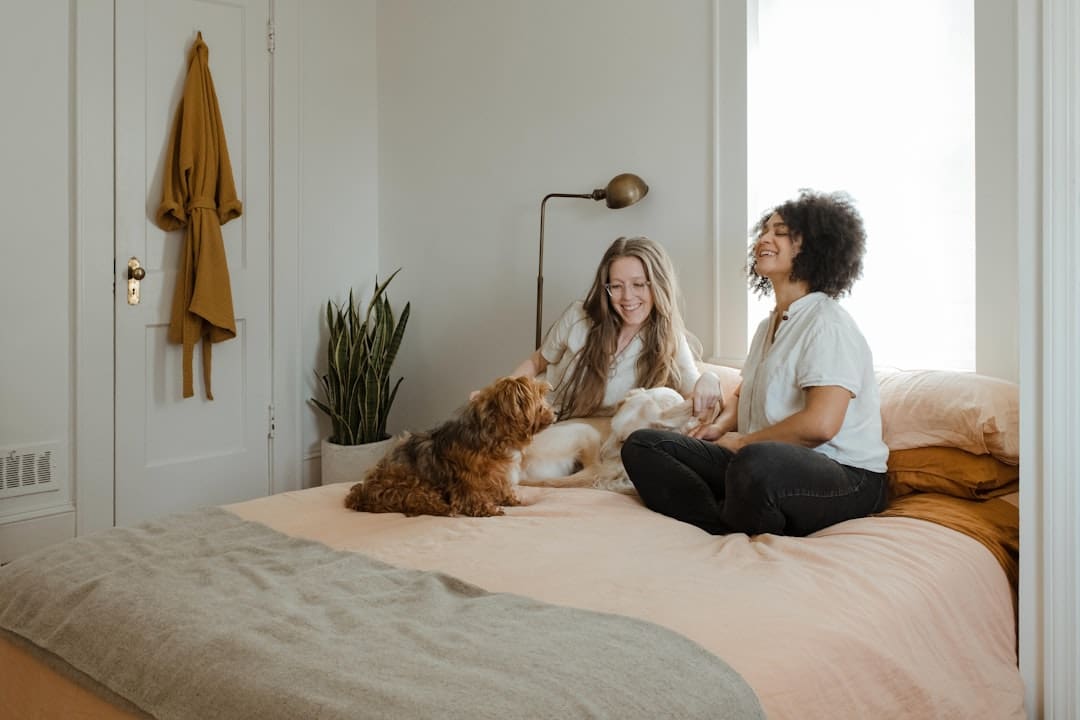support animal condo — woman in white long sleeve shirt sitting on bed beside brown dog